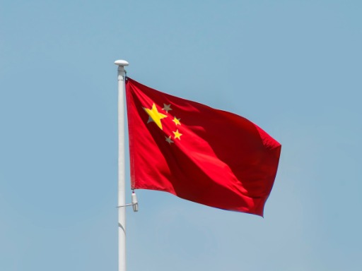 Chinesische Flagge weht im hellblauem Himmel
