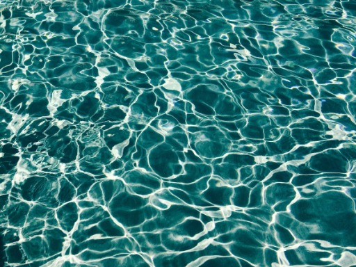 turkusowo-niebieska woda z wzorem refleksów świetlnych